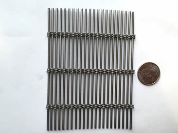 A piece of rectangular shape four ropes type cable mesh with a metal coin.
