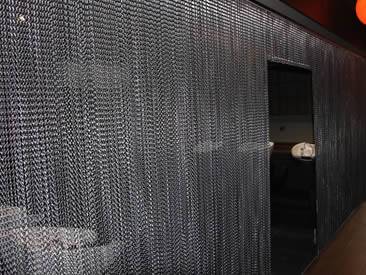 Silver white chain curtain used in restroom as space divider.