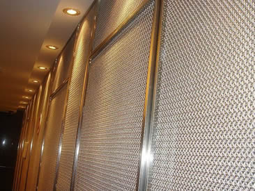 Wall with metal frames is decorated with architectural cable mesh.